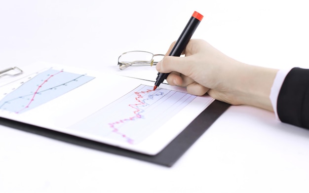 A hand holding a magnifying glass over a chart showing sales trends and inventory levels, highlighting the importance of data analysis in demand forecasting.