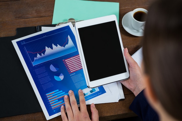 A split screen showing a laptop with financial software on one side and a person reviewing tax documents on the other. This represents the integration of technology with tax compliance.