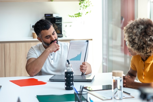 Venezuelan business owner reviewing financial documents in a modern office setting, illustrating strategic planning for reinvestment and tax incentives.