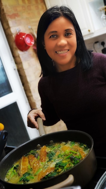 A split-screen image showing a Venezuelan family on one side, happily exchanging home-cooked meals using a mobile app, and on the other side, a single person receiving a delivery of that meal, also smiling. The overall tone is warm and positive, highlighting the benefits of community sharing.