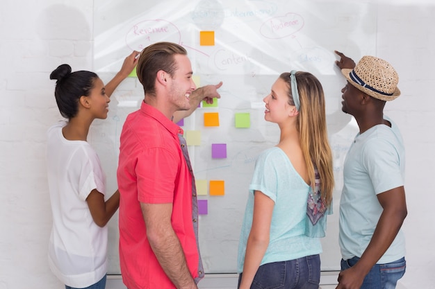 A visually appealing image depicting a Venezuelan digital marketing team brainstorming ideas on a whiteboard. The whiteboard is filled with keywords, marketing funnels, and social media icons, showcasing their strategic planning. The environment should look modern and collaborative, emphasizing the team's creativity and data-driven approach.