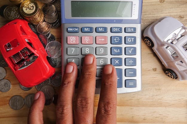 A close-up of hands using a calculator to determine debt capacity, with Venezuelan currency notes and financial documents scattered around.