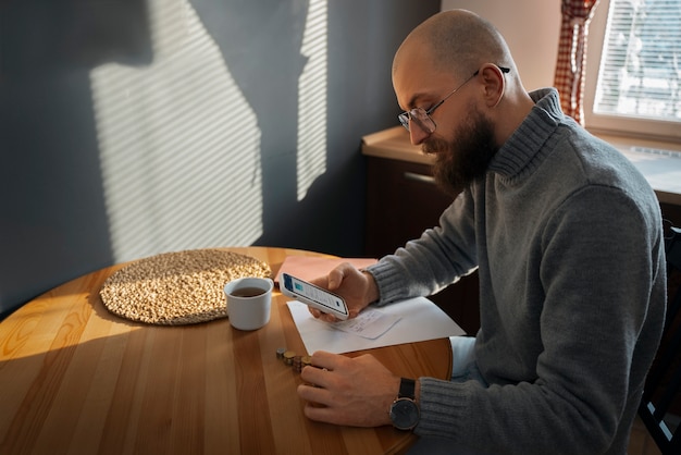 A person sitting at a table in Venezuela, focused on writting a personal budget on a paper.