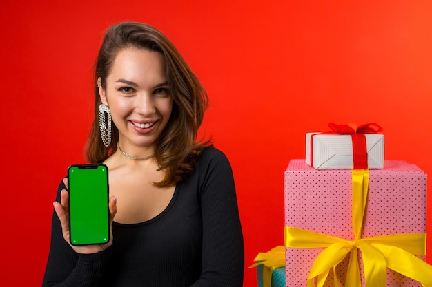 A person holding a smartphone displaying a loyalty rewards app with numerous discount offers available. The background shows a bustling Venezuelan marketplace, blending the digital savings with the local shopping experience.